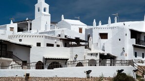 A white building with a bell tower, surrounded by similar white structures.