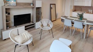 Una sala de estar moderna con chimenea, un comedor y una cocina.