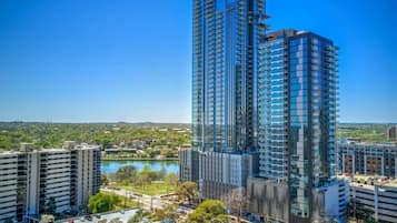 A high-rise building with multiple floors, surrounded by other buildings and a body of water.