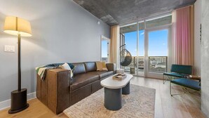 Ein modernes Wohnzimmer mit einer Ledersofa, einem Couchtisch und einer Stehlampe.