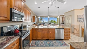A spacious kitchen with wooden cabinets, stainless steel appliances, and a large island.