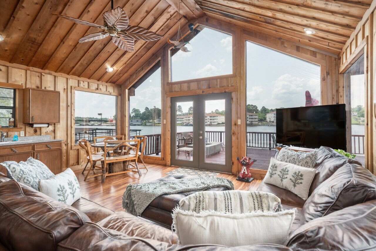 Amplia sala de estar con techo de madera, un televisor grande y vista al exterior.