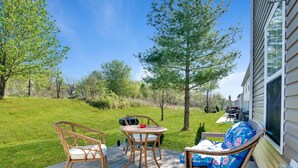 Eine Terrasse mit Korbmöbeln, einem Tisch und einem Stuhl.