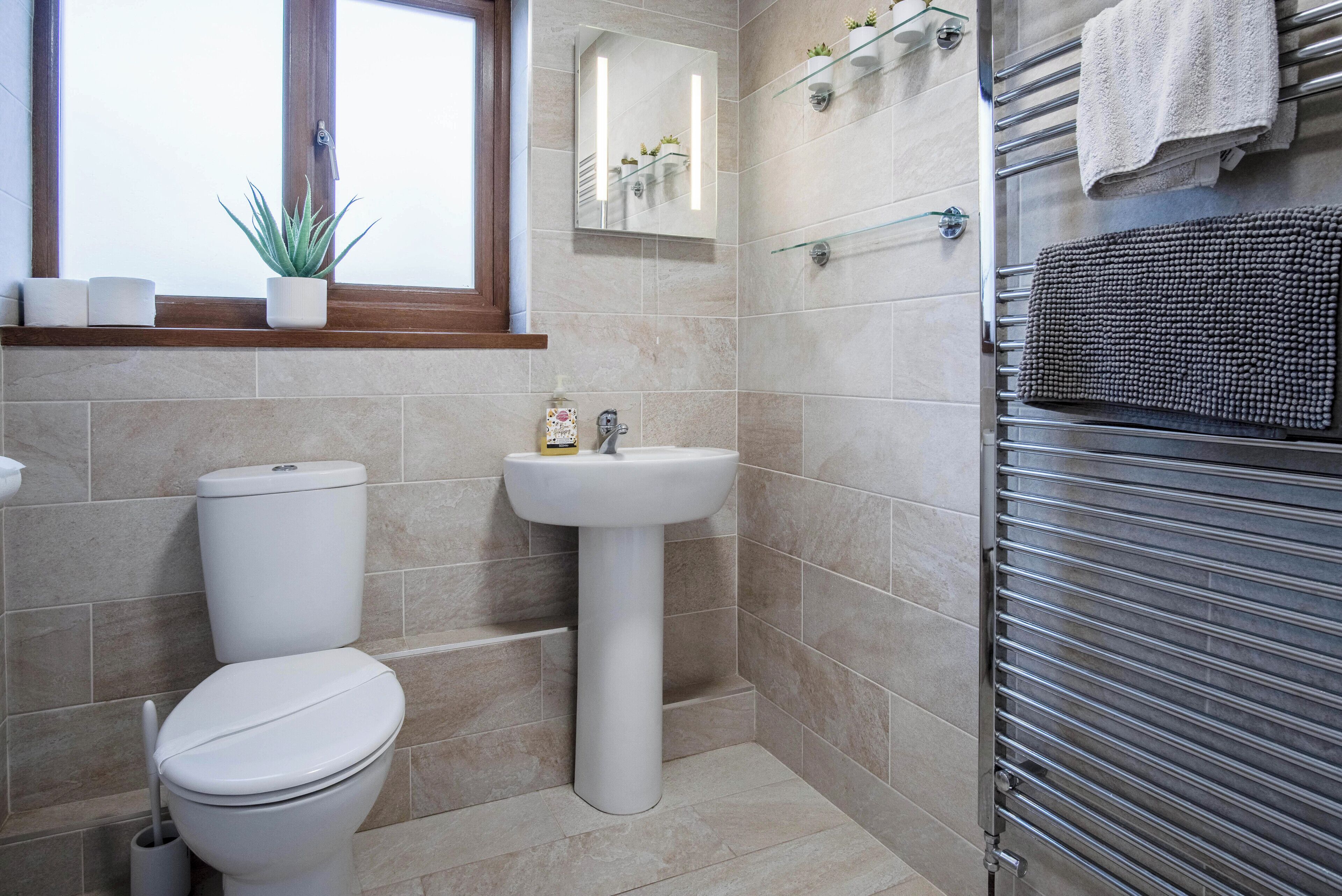A bathroom with a toilet, sink, and towel rack.