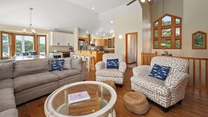 A spacious living room with a sofa, patterned armchairs, a coffee table, and a ceiling fan. - Z's By The Sea: Private Pool | Hot Tub | Rec Room (Kitty Hawk)