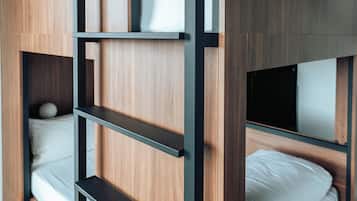 Una cama litera con estructura de madera y estantes de metal negro.