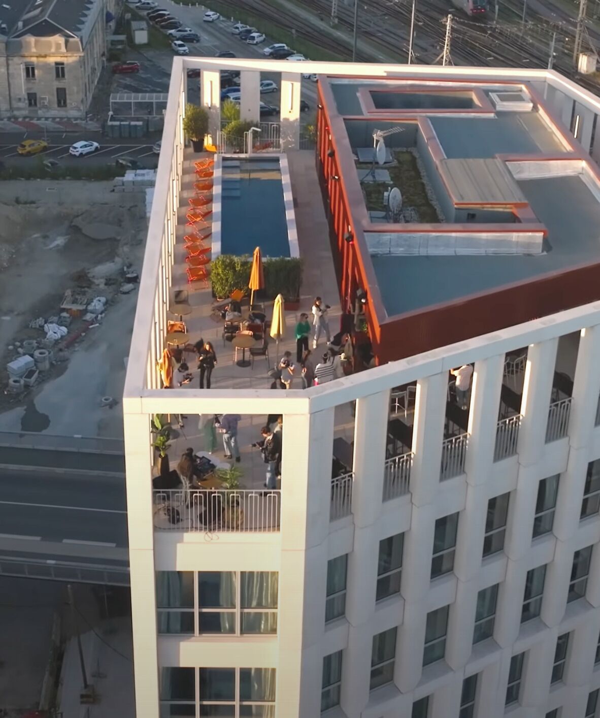 Ein modernes Gebäude mit Pool auf dem Dach und einer Außenbereich-Sitzgelegenheit.