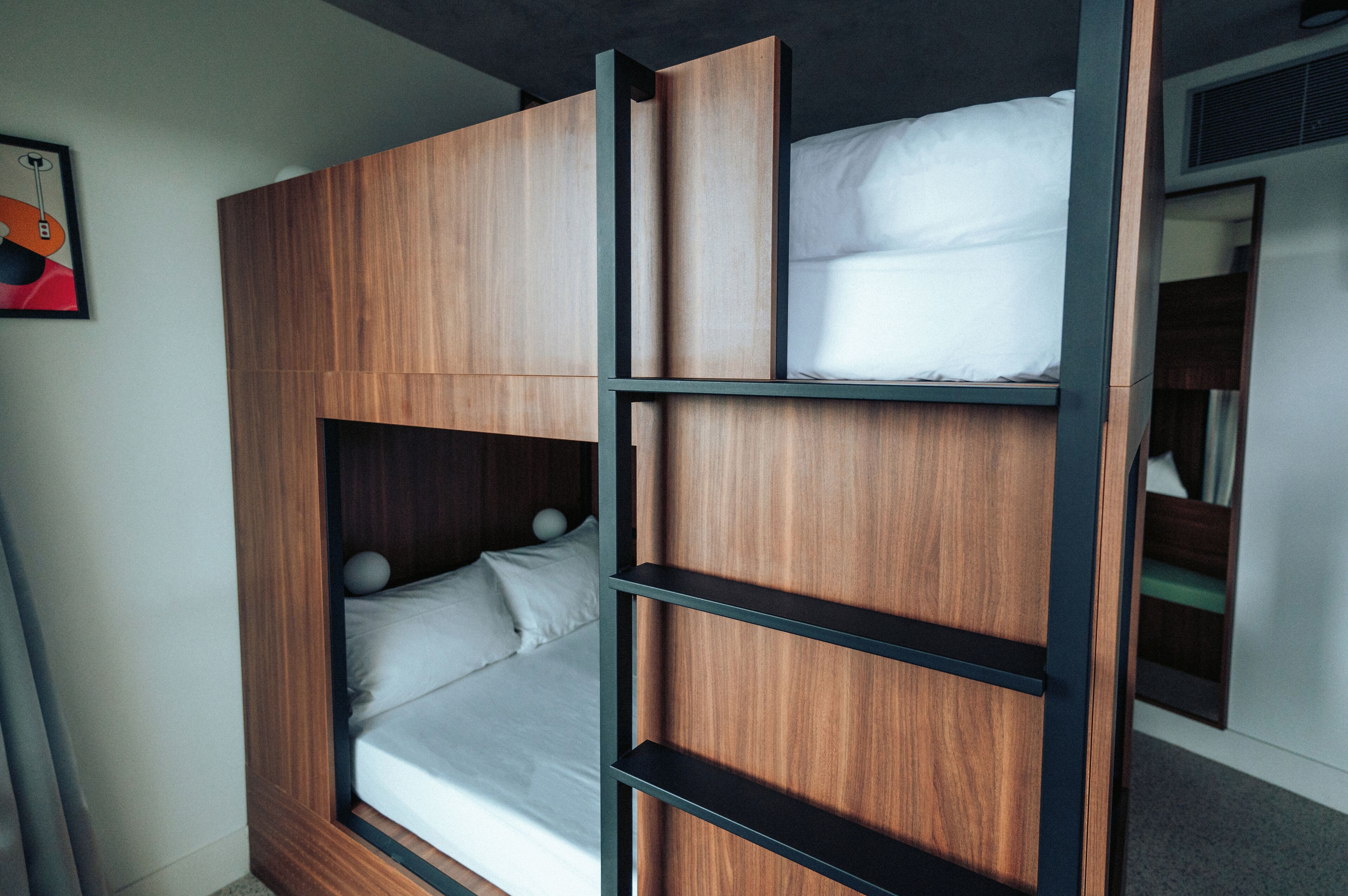 A compact room with a bunk bed, wooden paneling, and a small shelf.
