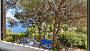 A patio with a swing chair, a view of the sea, and a stone pathway. - Villa Ottagonale, Capo Perla (Capoliveri)
