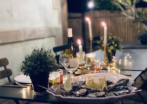 A dining table set with oysters, candles, and a potted plant. - VILLA CONSTANTINE A 2 PAS DU PORT DE BOYARDVILLE (Saint-Georges-d´Oléron)