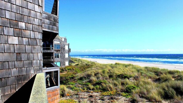 Um edifício à beira-mar com vista para a praia e o oceano.