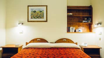 Une chambre à coucher avec un lit en bois, une bibliothèque et un tableau encadré accroché au mur.