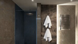 A modern bathroom with a walk-in shower, a towel rack with two towels, and a built-in towel warmer. - San Francesco Heritage Hotel (Alghero)