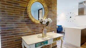 Une salle de bain avec un lavabo blanc, un miroir avec un cadre doré et un vase rempli de fleurs.