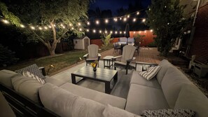 Eine Außenpatio mit einer Couch, Sesseln und einem Tisch.