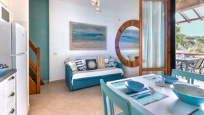 Un espacio habitable compacto con una cama, una mesa de comedor y vistas al exterior.