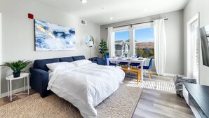 A modern bedroom with a bed, a desk, and a view of the landscape. - Sparks Marina 2BR · Mountain Views, Pool & Gym (Sparks)