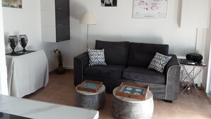A modern living room with a dark sofa, two side tables, a coffee table, and a map on the wall.