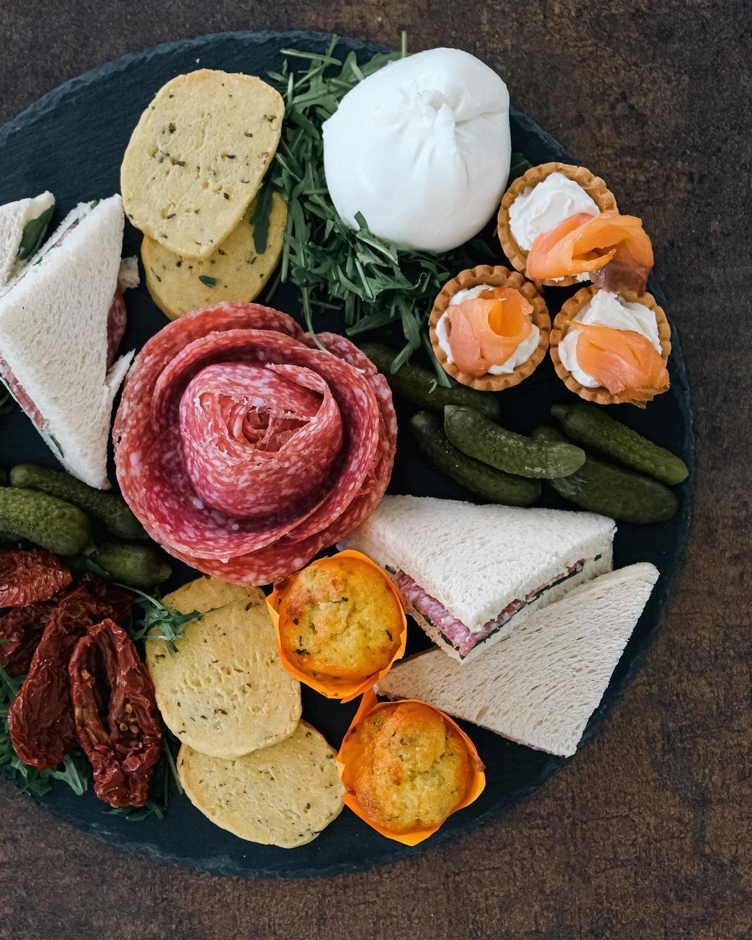 Eine Platte mit verschiedenen Wurstwaren, Käse und Brot.