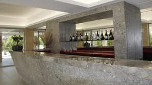 A modern bar area with marble countertops and shelves displaying bottles. - Kairos Resort (Piedimonte San Germano)