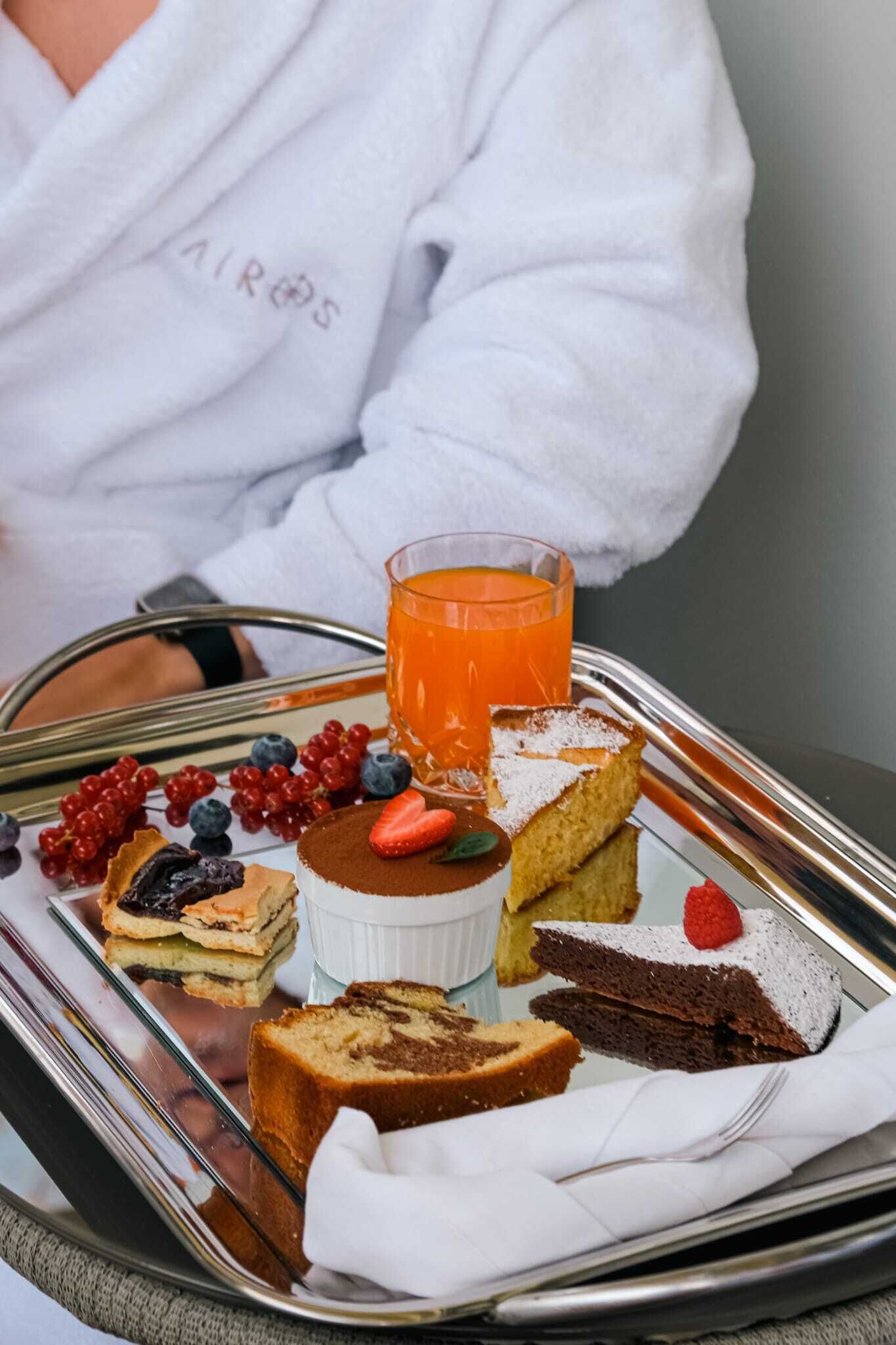 Un plateau contenant divers desserts et un verre de jus d’orange.