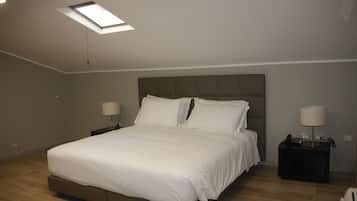 A bedroom with a bed, two bedside tables, a ceiling light, and a skylight.