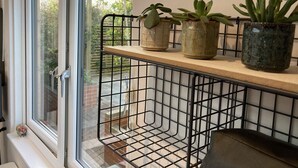 A window with a metal grid shelf holding potted plants. - Contemporary Guest House With Outside Barrel Sauna (Wadebridge)