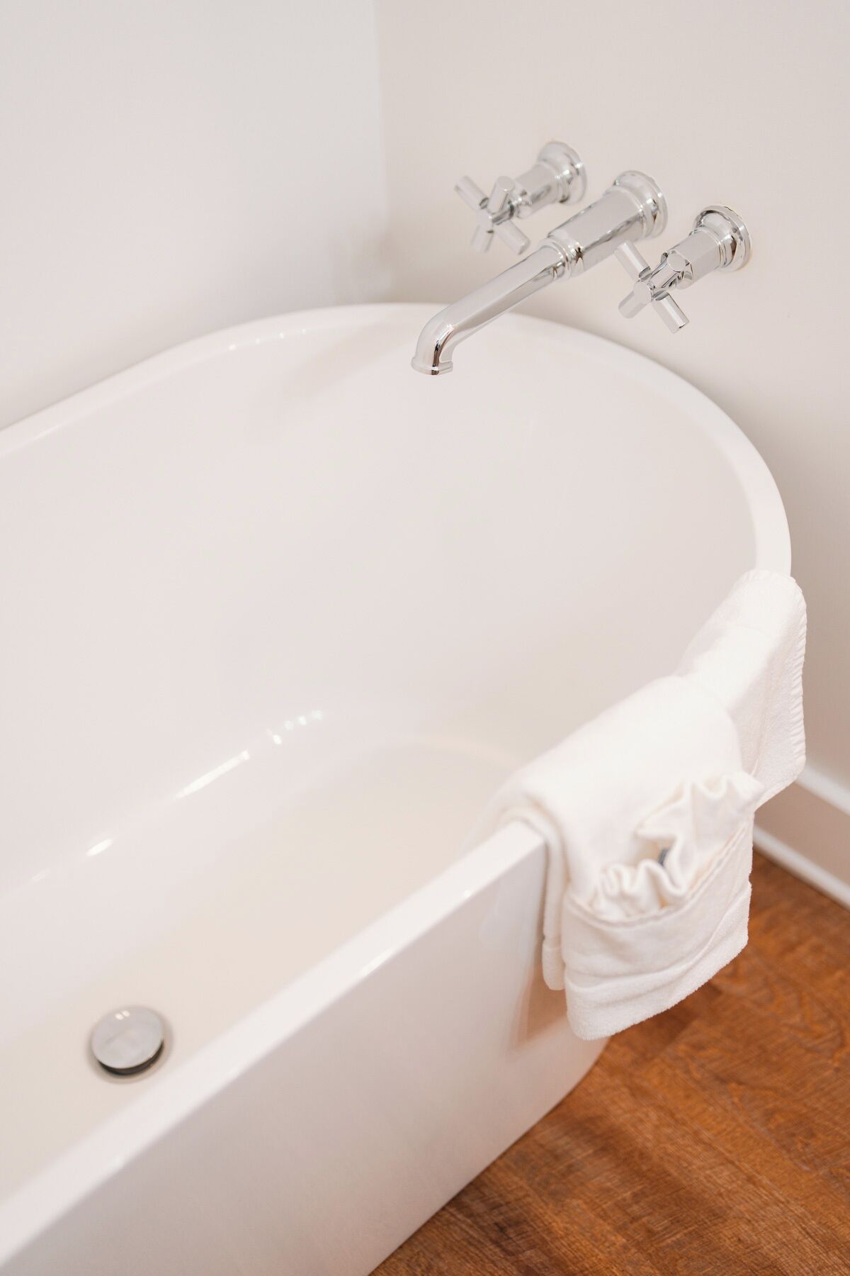 Eine weiße Badewanne mit einem Wasserhahn und einem Ablauf.