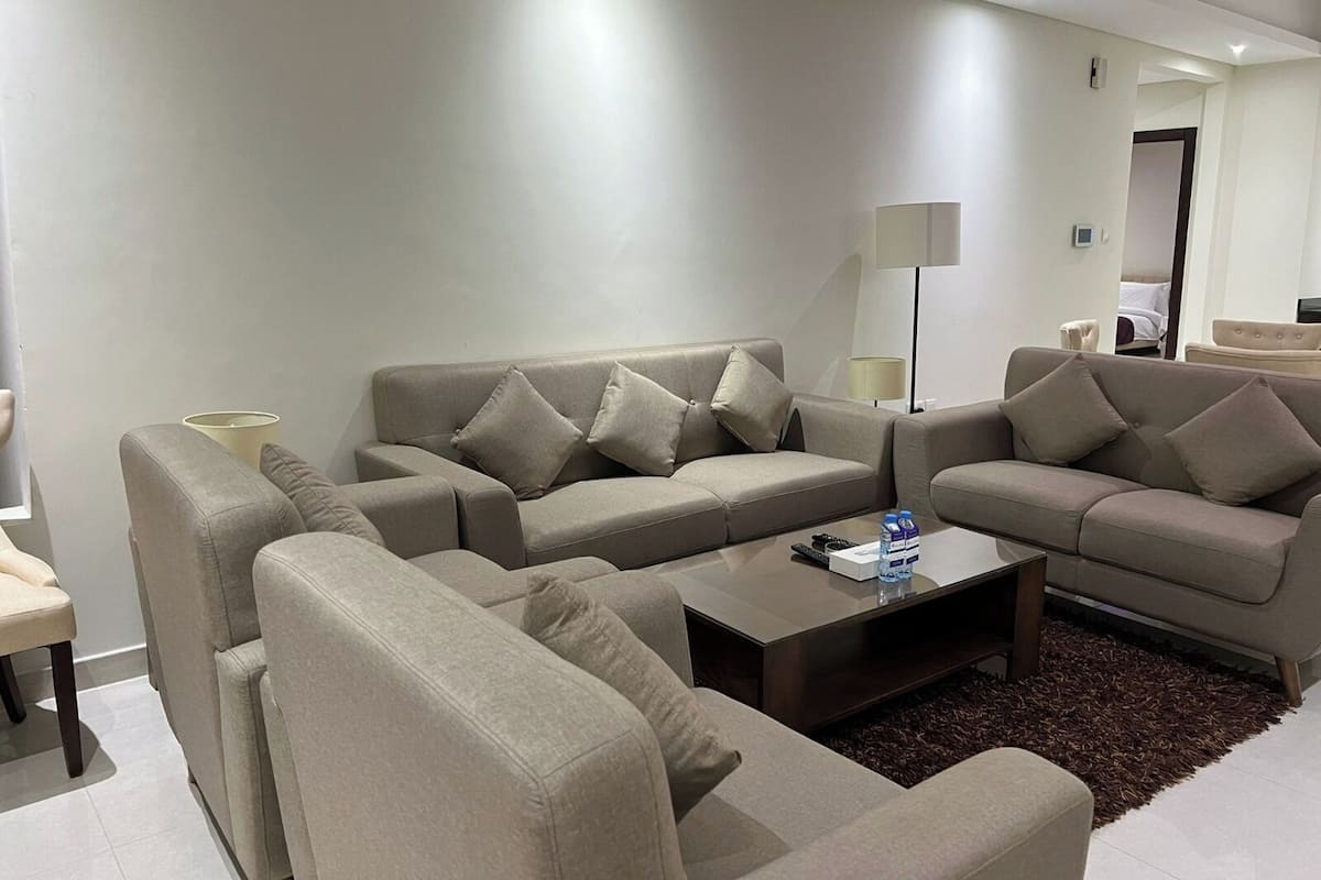 A modern living room with two sofas, a coffee table, and a lamp.