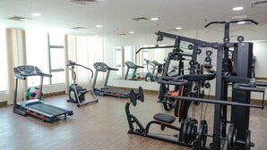 Een sportschool met loopbanden, elliptische trainers en gewichthefapparatuur.
