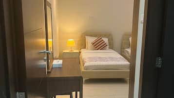 Relax in a stylish room with a tufted headboard, bedside table, and wooden desk.