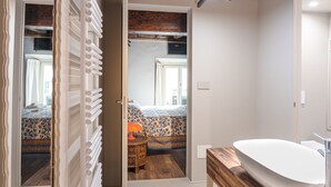 Un baño con tocador de madera, lavabo blanco y espejo.