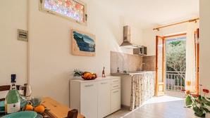 Eine moderne Küche mit Essbereich, einem Gemälde und Blick ins Freie.