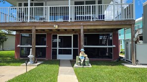 A two-story building with a porch, a statue, and a small garden. - Riverfront Retreat-Private Dock; Fishing, Boating & Peaceful Getaway in Welaka (Welaka)
