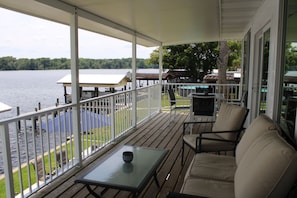 A covered outdoor deck with a view of a lake, a pool, and a gazebo. - Riverfront Retreat-Private Dock; Fishing, Boating & Peaceful Getaway in Welaka (Welaka)