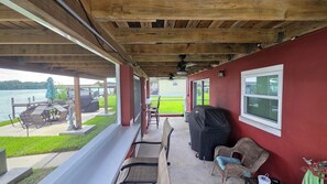 A covered patio with outdoor furniture, a grill, and a view of a grassy area. - Riverfront Retreat-Private Dock; Fishing, Boating & Peaceful Getaway in Welaka (Welaka)