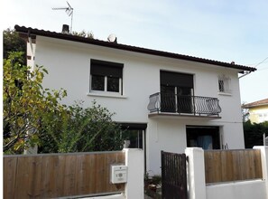 Enjoy a home away from home with a balcony offering a view, a bathtub, and a brown roof.