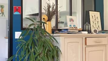 Une cuisine dotée d’une grande fenêtre, de placards, d’une plante en pot et de divers ustensiles de cuisine.