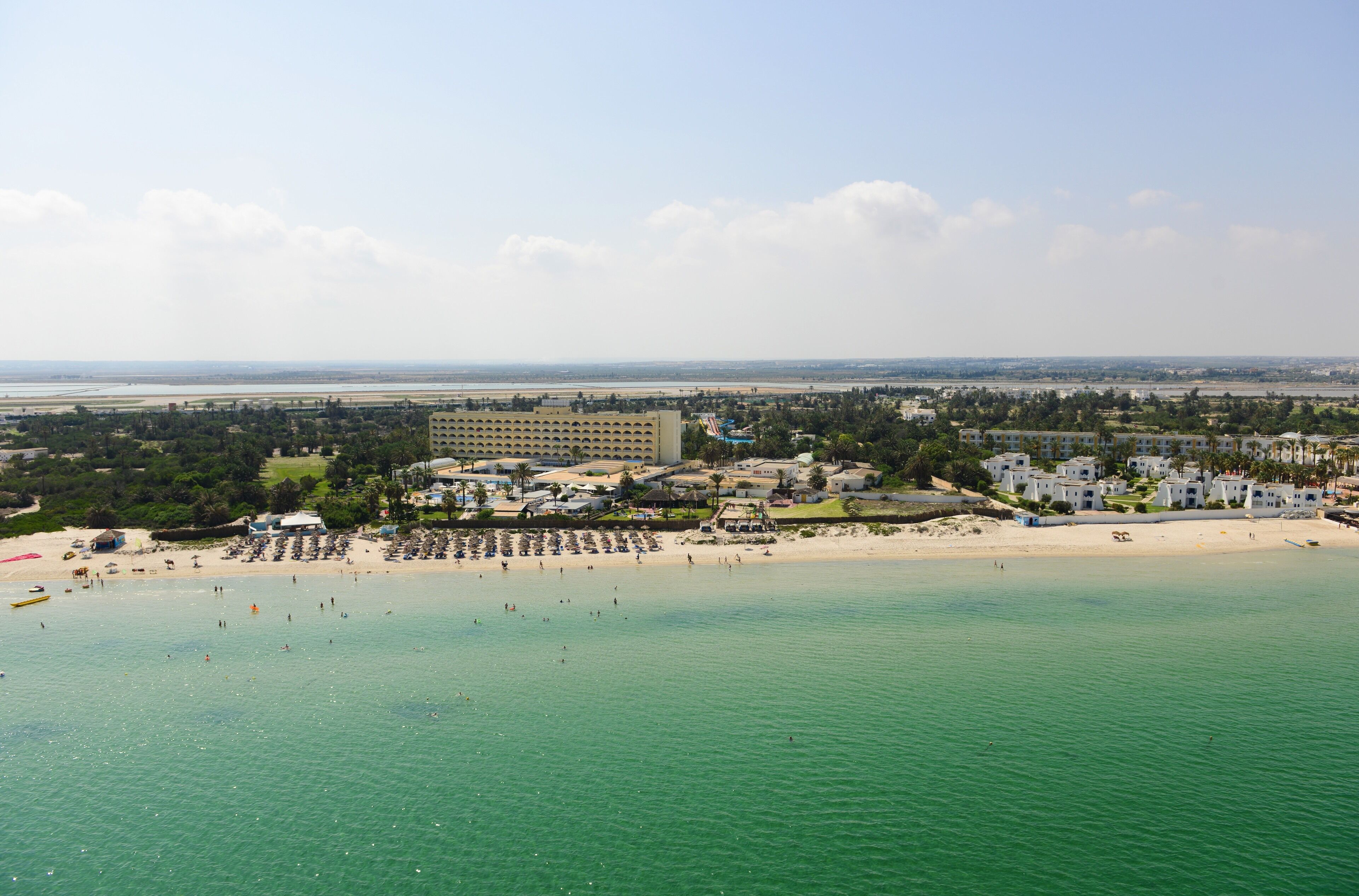 Une station balnéaire dotée de villas en bord de mer, d’une plage de sable et d’un port de plaisance.