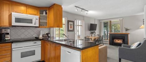 A modern kitchen with wooden cabinets, a built-in microwave, and a dishwasher.