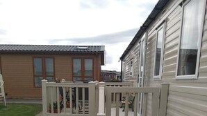 A residential area with a white wooden deck leading to a house.