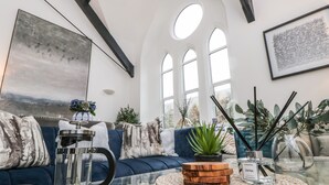 A modern living room with a sofa, coffee table, and decorative items. - Pilgrims Loft (Ventnor)