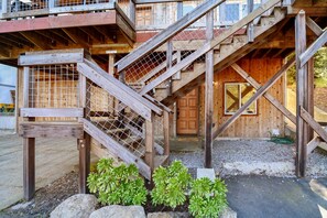 Staircase leads to the entrance of a rustic building with a wooden door and lush greenery.