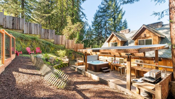 Une cabane en bois dotée d’un bain à remous, d’un espace salon extérieur et d’une terrasse.
