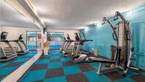 Un gimnasio con cintas de correr, elípticas y una prensa de banca.