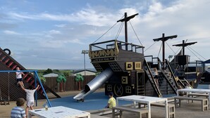 Ein Spielplatz mit Piratenschiff-Motiv, inklusive Rutschen und Klettergerüsten.