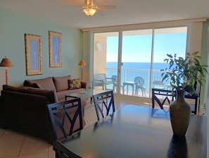 Relax in this inviting living area with a sofa, dining table, and balcony offering ocean views.