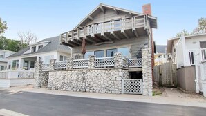 Une maison à deux étages avec une façade en pierre, un balcon et un garage.