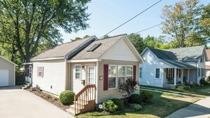A single-story house with a front porch, a small front yard, and a garage. - Sweet Retreat in South Haven • 2 Blocks from Beach (South Haven)