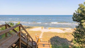 A wooden staircase leading to a beach with ocean views. - Carriage House (South Haven)
